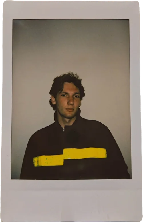 Polaroid portrait of Henry Collins in a dark jacket with a yellow stripe
